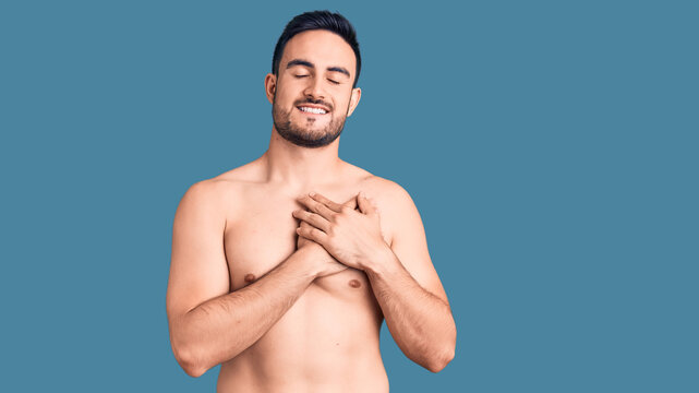 Young handsome man wearing swimwear smiling with hands on chest with closed eyes and grateful gesture on face. health concept.