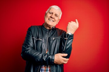 Senior handsome hoary man wearing casual shirt and jacket over isolated red background with a big smile on face, pointing with hand and finger to the side looking at the camera.