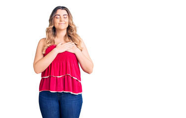 Young caucasian woman wearing casual clothes smiling with hands on chest with closed eyes and grateful gesture on face. health concept.