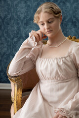A young Regency period woman in a pale pink gown