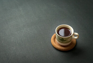 Coffee cup on rustic black tabletop. Top view with copy space.