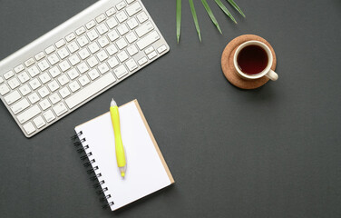 Flat lay of keyboard, coffee and notepad with pen. Copy space.