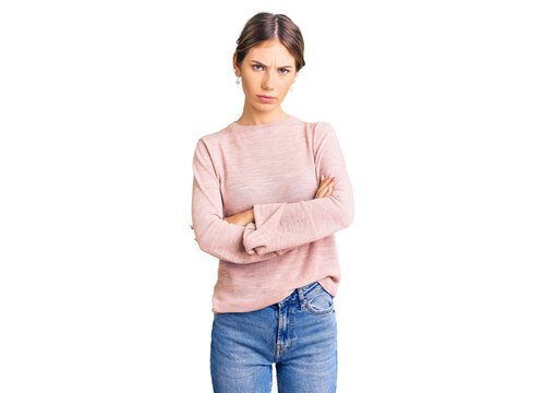 Beautiful caucasian woman with blonde hair wearing casual winter sweater skeptic and nervous, disapproving expression on face with crossed arms. negative person.