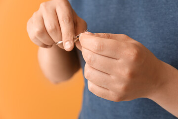 Fototapeta premium Asian man doing manicure on color background, closeup