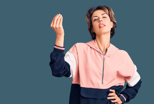 Young beautiful woman wearing sportswear doing italian gesture with hand and fingers confident expression