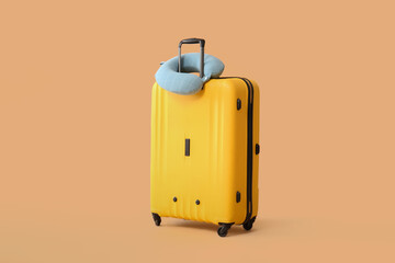 Packed suitcase and travel pillow on color background