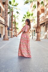 Beautiful young woman wearing fashionable clothes walking down the street