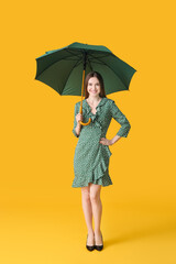 Beautiful woman with umbrella on color background