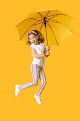 Happy little girl with umbrella on color background