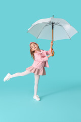 Cute little girl with umbrella on color background