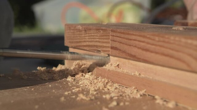 Close Up Of Worker Using Electric Drill Driver Making Hole In Wooden Plank. 