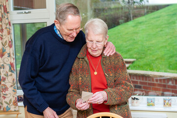 An elderly couple reading a gift card