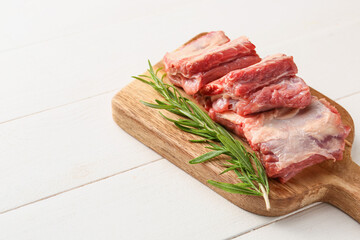 Raw beef short ribs with herbs on table