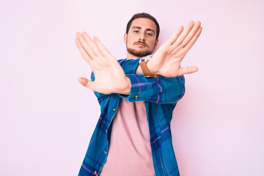 Young handsome man wearing casual clothes rejection expression crossing arms and palms doing negative sign, angry face
