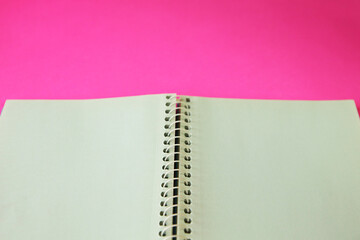 blue spiral notebook on pink background
