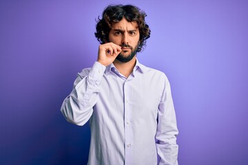 Young handsome business man with beard wearing shirt standing over purple background mouth and lips...