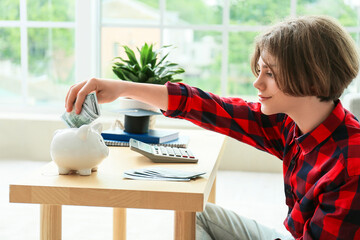 Teenage boy with savings for education and calculator at home
