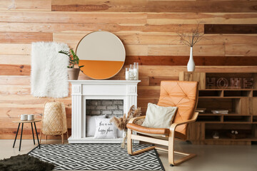 Stylish fireplace with armchair in interior of living room