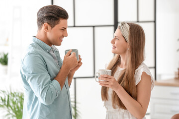 Obraz na płótnie Canvas Happy young couple drinking tea at home
