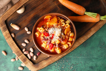 Bowl with tasty pasta and beans on color background