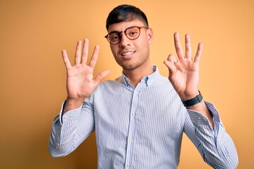 Young handsome hispanic business man wearing nerd glasses over yellow background showing and...