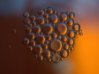 Closeup golden yellow bubbles oil in water with orange light , blurred abstract background, macro image ,droplets for card design