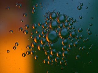 Closeup golden yellow bubbles oil in water with orange light , blurred abstract background, macro image ,droplets for card design