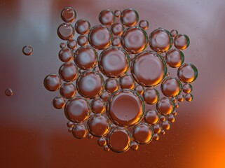 Closeup golden yellow bubbles oil in water with orange light , blurred abstract background, macro image ,droplets for card design