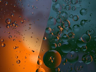 Closeup golden yellow bubbles oil in water with green orange light , blurred abstract background, macro image ,droplets for card design