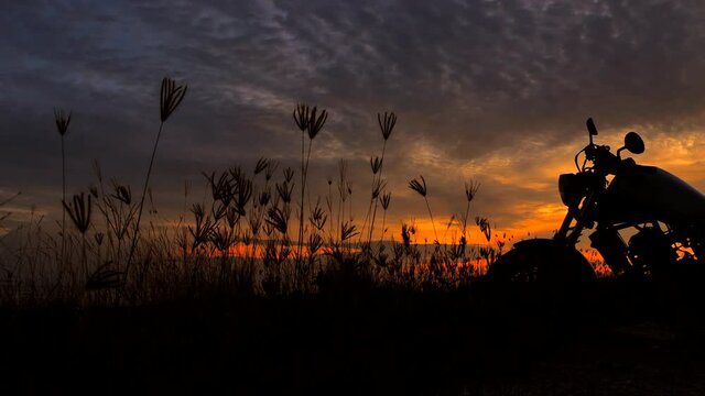 Motorcycle silhouette at sunset time near sea coast, tracking shot