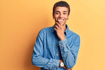 Young african amercian man wearing casual clothes smiling looking confident at the camera with crossed arms and hand on chin. thinking positive. © Krakenimages.com