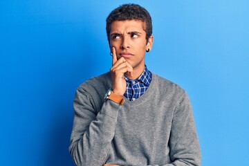 Young african amercian man wearing casual clothes serious face thinking about question with hand on chin, thoughtful about confusing idea