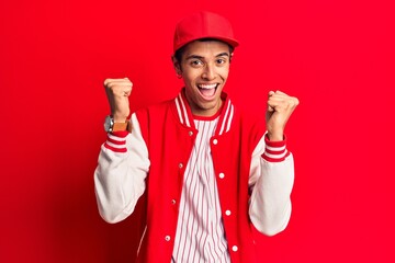 Young african amercian man wearing baseball uniform screaming proud, celebrating victory and success very excited with raised arms