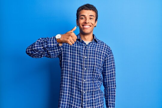 Young african amercian man wearing casual clothes doing happy thumbs up gesture with hand. approving expression looking at the camera showing success.