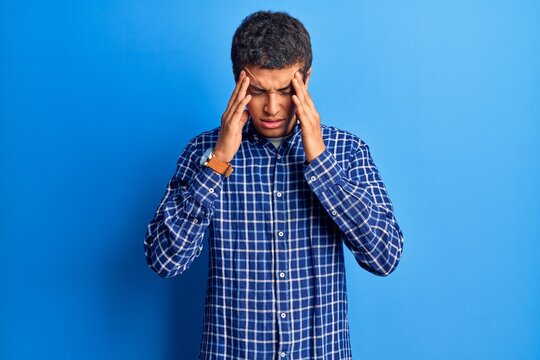 Young african amercian man wearing casual clothes with hand on head for pain in head because stress. suffering migraine.