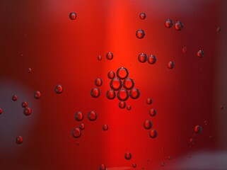 Closeup bubbles oil in water on red blurred abstract background, macro image ,droplets for card design, sweet color	