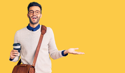 Young handsome hispanic man wearing leather bag and drinking take away coffee celebrating victory with happy smile and winner expression with raised hands