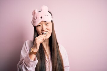 Young beautiful asian woman wearing pajama brushing her teeth using tooth brush and oral paste, cleaning teeth and tongue as healthy health care morning routine