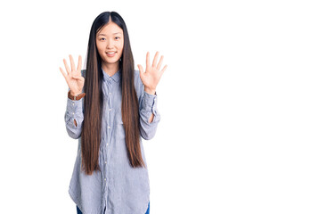 Young beautiful chinese woman wearing casual shirt showing and pointing up with fingers number nine...