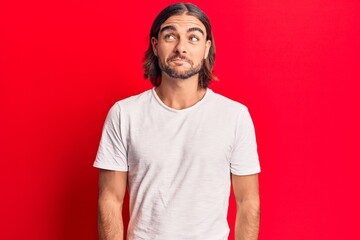 Young handsome man wearing casual clothes smiling looking to the side and staring away thinking.