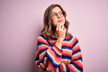 Young beautiful blonde girl wearing glasses and casual sweater over pink isolated background with hand on chin thinking about question, pensive expression. Smiling and thoughtful face. Doubt concept.