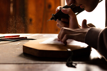 young man carving figures on wood