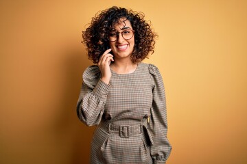 Beautiful arab businesswoman wearing glasses having conversation talking on smartphone with a happy face standing and smiling with a confident smile showing teeth