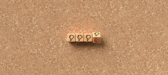 cubes with thumb-down icons and one with thumbs-up icon on cork background