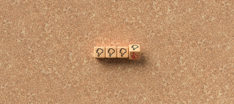 cubes with thumb-down icons and one with thumbs-up icon on cork background