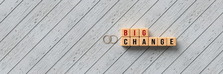 wedding rings and cubes with message BIG CHANGE on wooden background