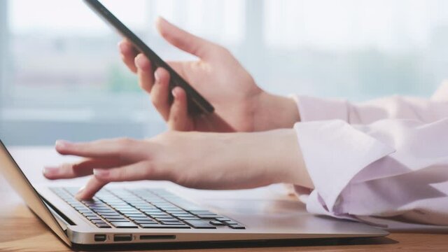 Business technology. Cyber security. Female hands using laptop smartphone for online operation.
