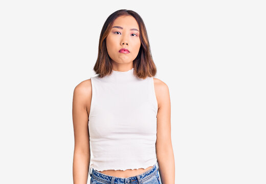 Young beautiful chinese girl wearing casual clothes with serious expression on face. simple and natural looking at the camera.