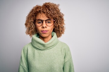 Young beautiful african american woman wearing turtleneck sweater and glasses Relaxed with serious expression on face. Simple and natural looking at the camera.