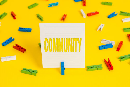Conceptual hand writing showing Community. Concept meaning group of showing with a common characteristics living together Colored clothespin papers empty reminder yellow floor office